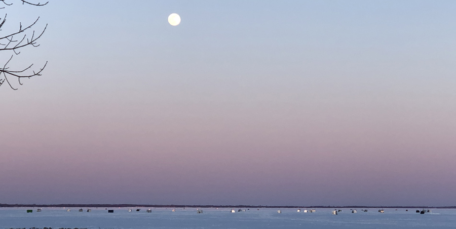 A full moon over spearing shanties on Lake Winnebago off Neenah. - Photo credit: DNR