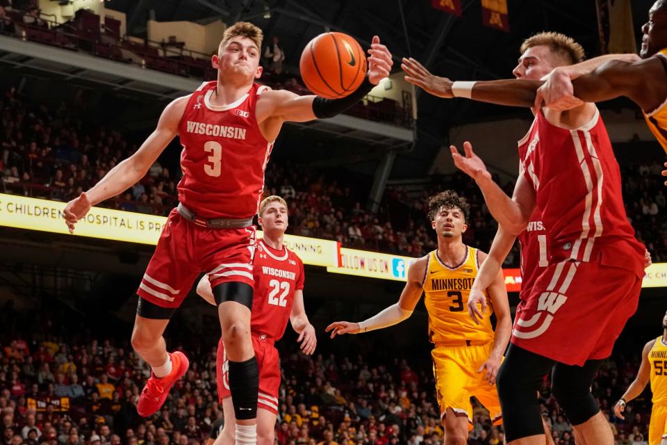 Wisconsin guard Connor Essegian (3) grabs a rebound in front of forward Steven Crowl (22) Minnesota forward Dawson Garcia (3) and Wisconsin forward Tyler Wahl, right, during the first half Sunday night.
