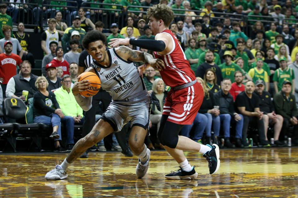 Oregon guard Rivaldo Soares fights past Wisconsin guard Max Klesmit as the Oregon Ducks host Wisconsin in the quarterfinal round of the NIT Tuesday, March 21, 2023 at Matthew Knight Arena in Eugene, Ore.