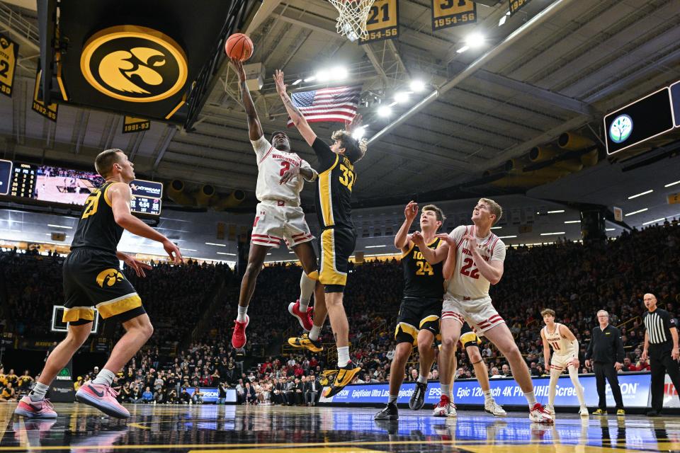 Wisconsin guard AJ Storr goes to the basket as Iowa forwards Owen Freeman (32), Pryce Sandfort (24) and Payton Sandfort (20) defend and UW forward Steven Crowl positions himself for a rebound Saturday.