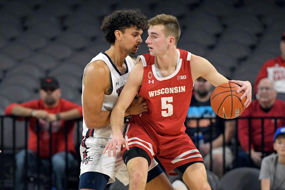 Tyler Wahl of the Badgers drives against Dan Fotu of St. Mary&#39;s during the championship game of the 2021 Maui Invitational.