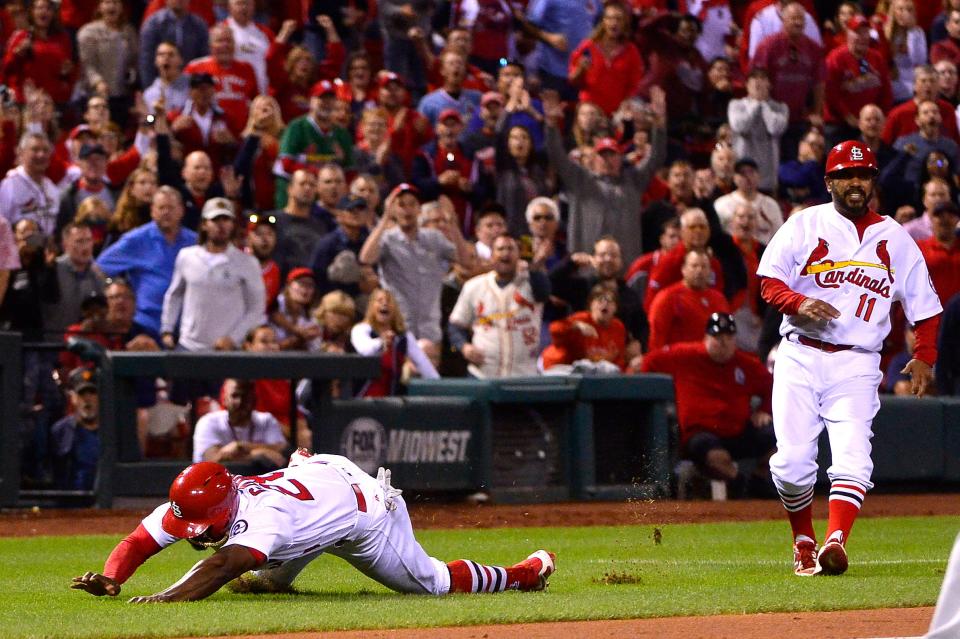 St. Louis Cardinals pinch runner Adolis Garcia (28) trips while running home attempting to score the tying run.